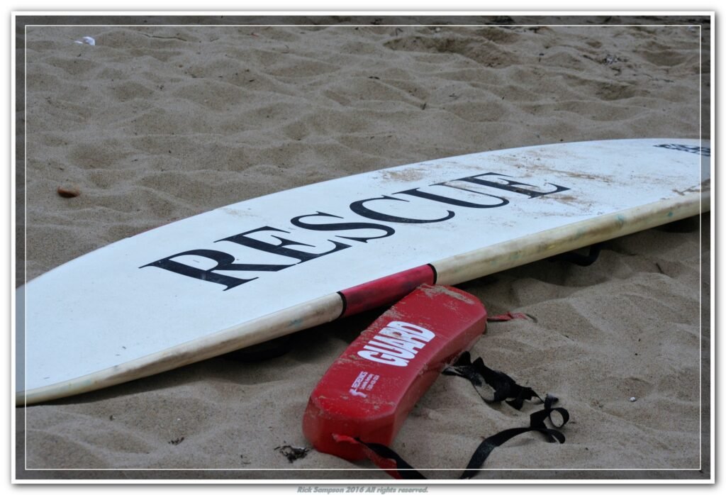 Lifeguard rescue buoy and Rescue Board with RESCUE printed on it.
